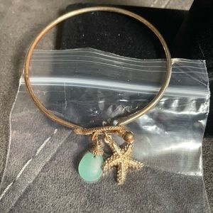 Gold tone bracelet with starfish and light green accent
